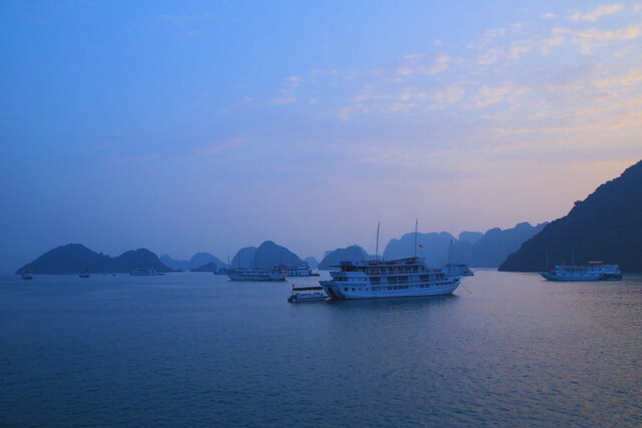 Peaceful evening view of Halong Bay Cruises on calm blue waters Vietnam